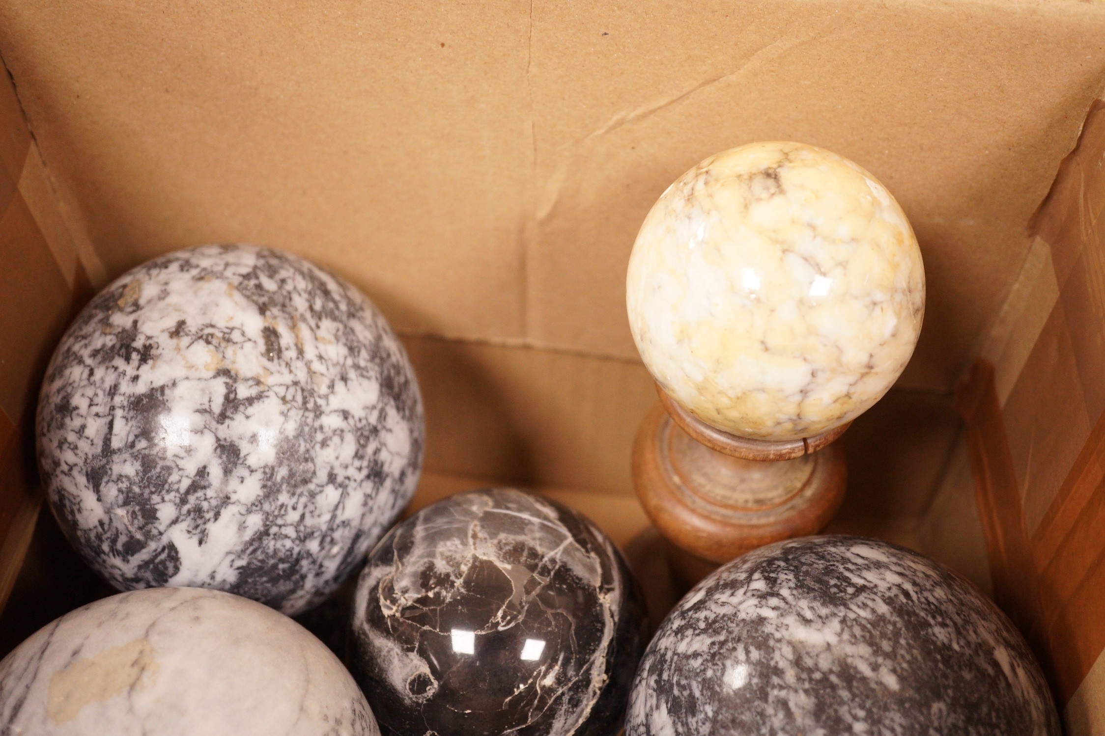 A quantity of carved marble balls on stands